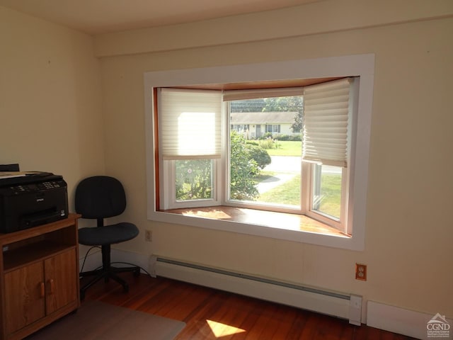 home office with a baseboard heating unit and wood finished floors