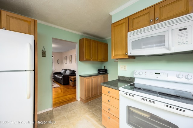 219 Rte 32, New Paltz, NY 12561 - kitchen featuring white appliances, dark countertops, crown molding, light tile patterned flooring, and brown cabinetry