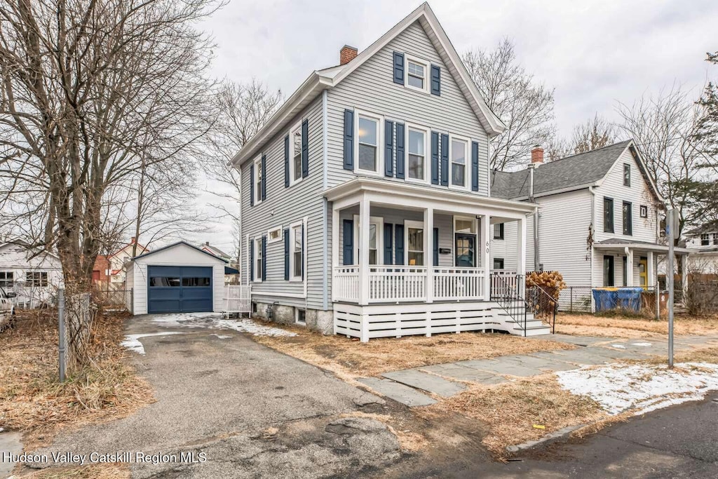 view of front property featuring a garage, an outbuilding, and covered porch