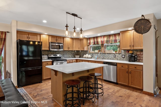 190 Deer Run Rd, Ashland, NY 12407 - kitchen with appliances with stainless steel finishes, a sink, light wood-type flooring, light countertops, and a kitchen breakfast bar