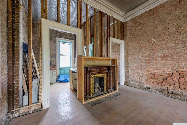8-10 Park Pl, Hudson, NY 12534 - unfurnished living room with ornamental molding, wood finished floors, an outdoor fireplace, and brick wall