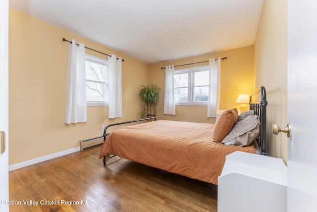 121 Rayna St, Hurley, NY 12443 - bedroom with a baseboard heating unit, wood finished floors, and baseboards
