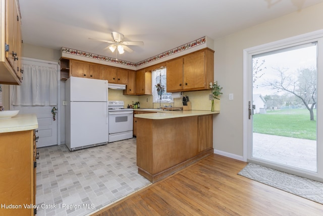 121 Rayna St, Hurley, NY 12443 - kitchen featuring white appliances, a peninsula, brown cabinetry, under cabinet range hood, and ceiling fan