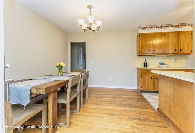 121 Rayna St, Hurley, NY 12443 - dining space featuring a chandelier, light wood finished floors, and baseboards