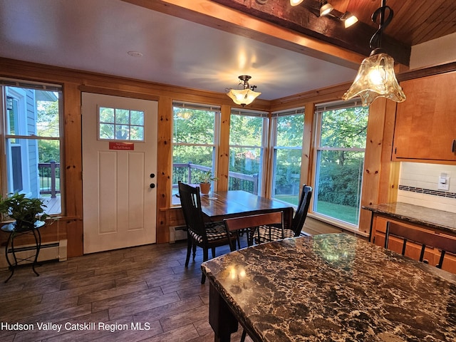 dining room with a baseboard radiator, dark wood-style flooring, and beamed ceiling