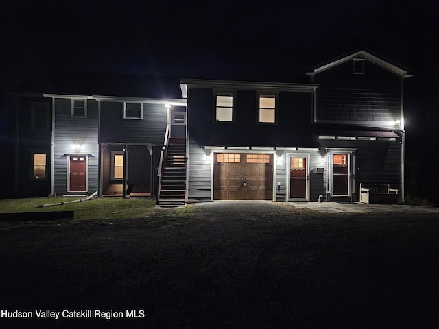 view of front of property featuring a garage and stairway
