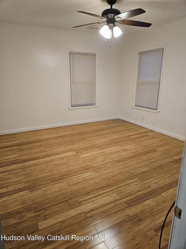 unfurnished room featuring light wood-style floors, ceiling fan, and baseboards
