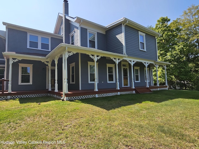 view of front of house with a front yard, covered porch, and a chimney