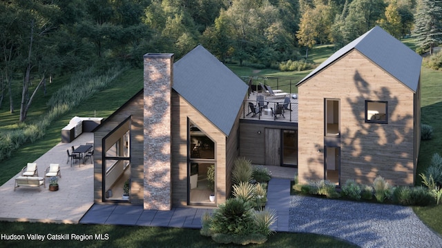 rear view of property featuring a patio and a balcony