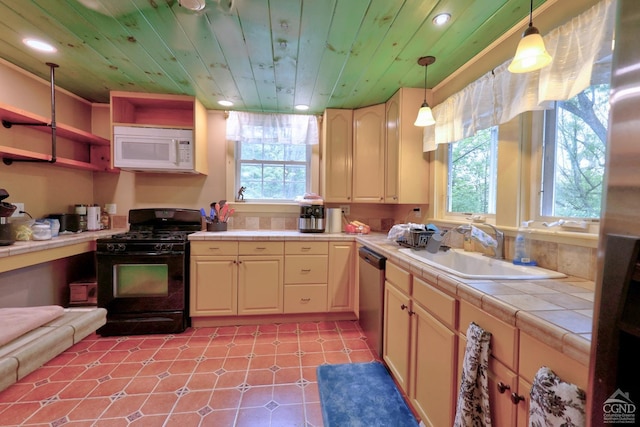 630 County Route 11, Ancram, NY 12502 - kitchen with white microwave, black gas stove, a sink, tile counters, and healthy amount of natural light