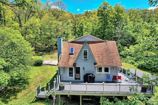 630 County Route 11, Ancram, NY 12502 - back of property with a chimney, a wooden deck, a forest view, a yard, and roof with shingles