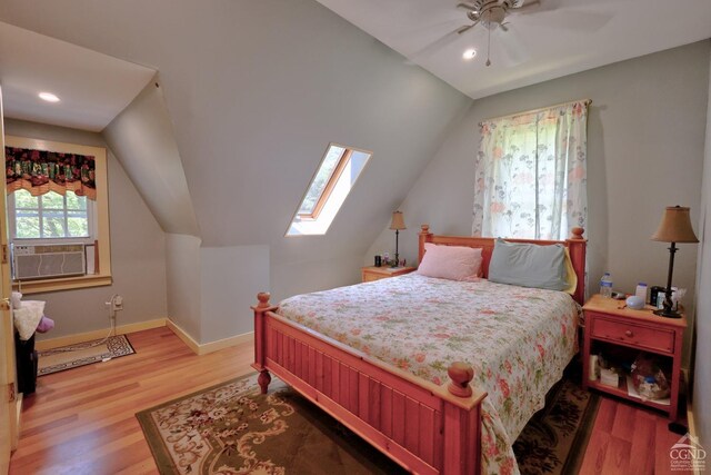 630 County Route 11, Ancram, NY 12502 - bedroom featuring wood finished floors, vaulted ceiling, cooling unit, a skylight, and baseboards