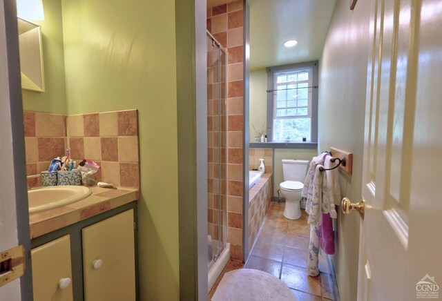 630 County Route 11, Ancram, NY 12502 - full bath featuring tiled shower, vanity, toilet, tile patterned floors, and a relaxing tiled tub