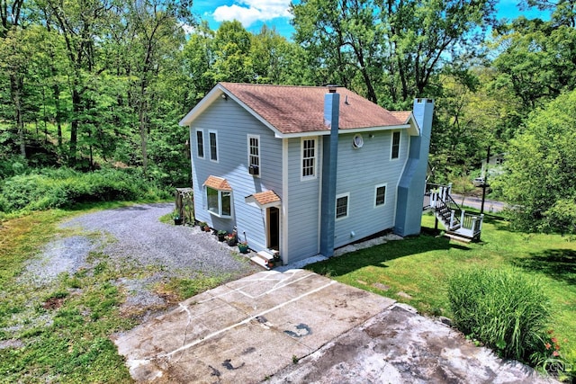 630 County Route 11, Ancram, NY 12502 - view of side of property with a chimney, a yard, stairway, a shingled roof, and driveway