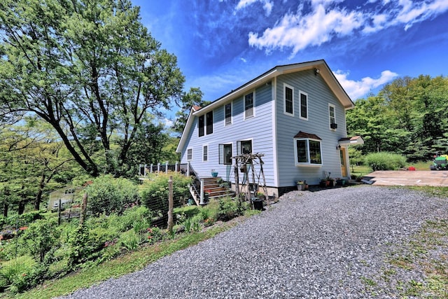 630 County Route 11, Ancram, NY 12502 - view of front of property with a chimney, a wooden deck, driveway, a patio, and stairs