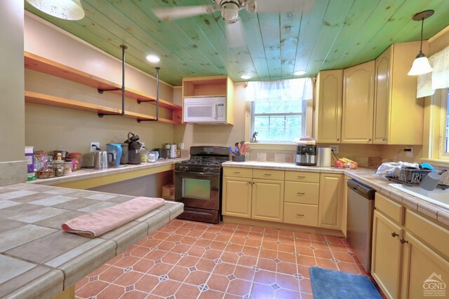 630 County Route 11, Ancram, NY 12502 - kitchen featuring black gas range oven, white microwave, tile countertops, dishwasher, and open shelves