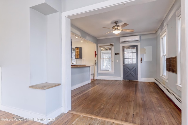 entrance foyer with a wall mounted AC, baseboards, a ceiling fan, baseboard heating, and hardwood / wood-style floors
