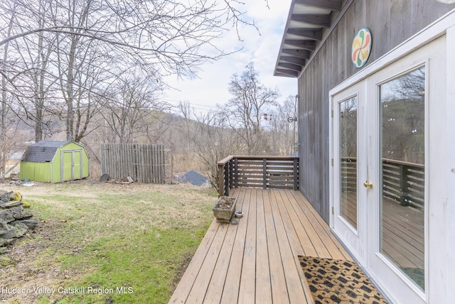 wooden deck with a yard, an outbuilding, and a storage shed