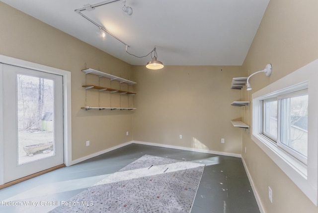 unfurnished dining area with finished concrete flooring, baseboards, and a healthy amount of sunlight