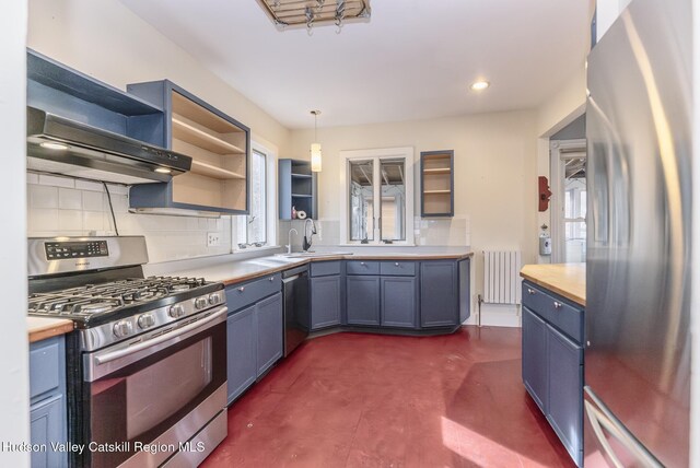 kitchen with radiator heating unit, tasteful backsplash, appliances with stainless steel finishes, a sink, and open shelves