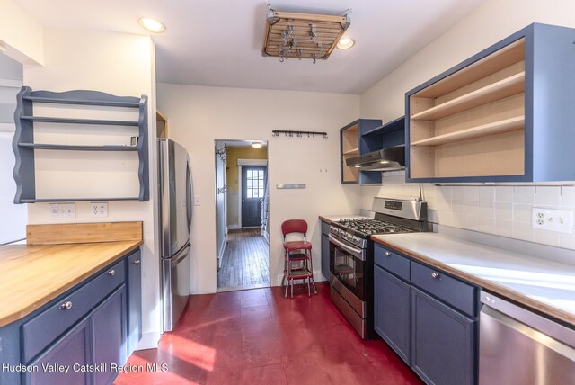 kitchen featuring wooden counters, blue cabinetry, stainless steel appliances, under cabinet range hood, and open shelves