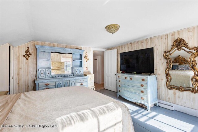 bedroom with wooden walls and vaulted ceiling