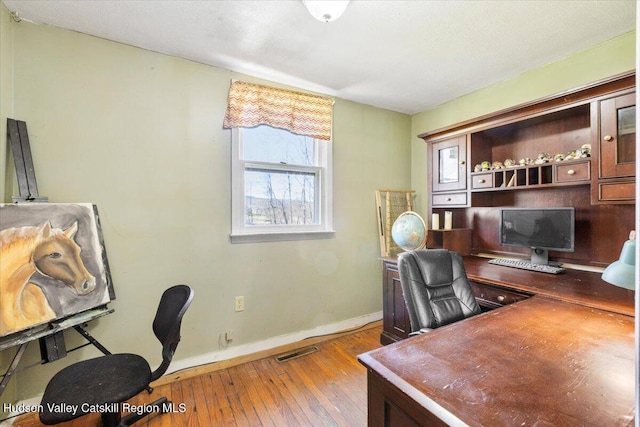 office space with visible vents, baseboards, plenty of natural light, and hardwood / wood-style floors
