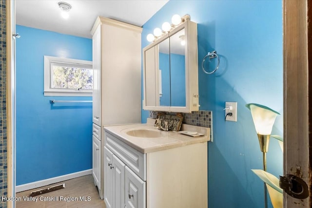 bathroom with vanity, baseboards, backsplash, and wood finished floors
