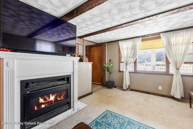 interior space with baseboards, carpet flooring, and a glass covered fireplace