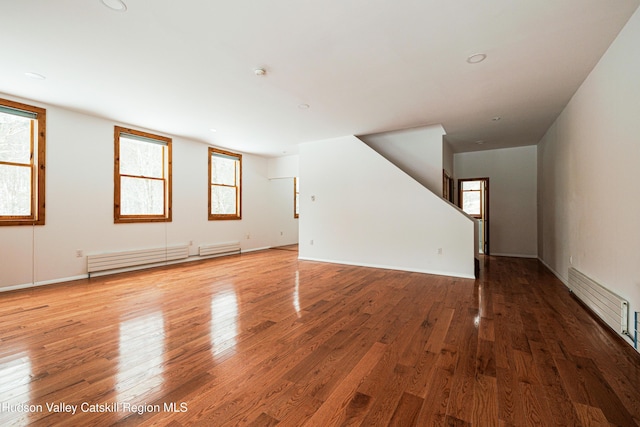 unfurnished room with a baseboard radiator and light wood-type flooring