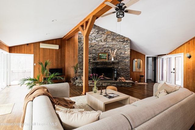 living room featuring wood-type flooring, lofted ceiling, and a fireplace