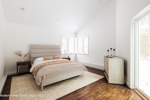 bedroom with a baseboard radiator, dark wood-type flooring, multiple windows, and high vaulted ceiling