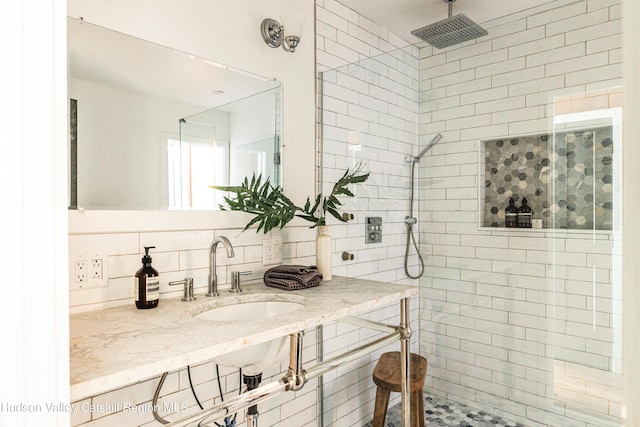 bathroom featuring sink, backsplash, and a tile shower