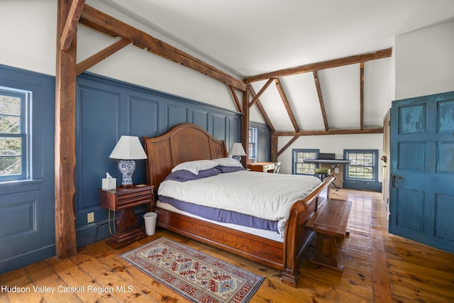 455 Post Hill Rd, Craryville, NY 12534 - bedroom with wood-type flooring, multiple windows, and a decorative wall