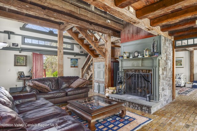 455 Post Hill Rd, Craryville, NY 12534 - living room with beam ceiling, stairs, brick flooring, and a fireplace with raised hearth