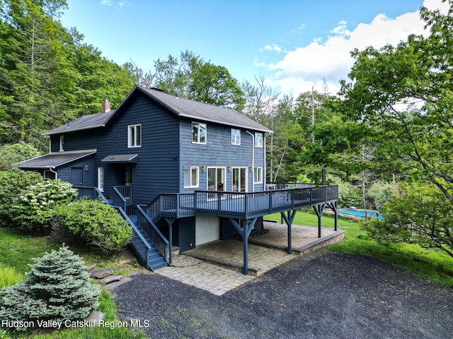 94 The Middle Way, Mount Tremper, NY 12457 - rear view of property featuring a wooden deck, a chimney, stairway, roof with shingles, and view of scattered trees