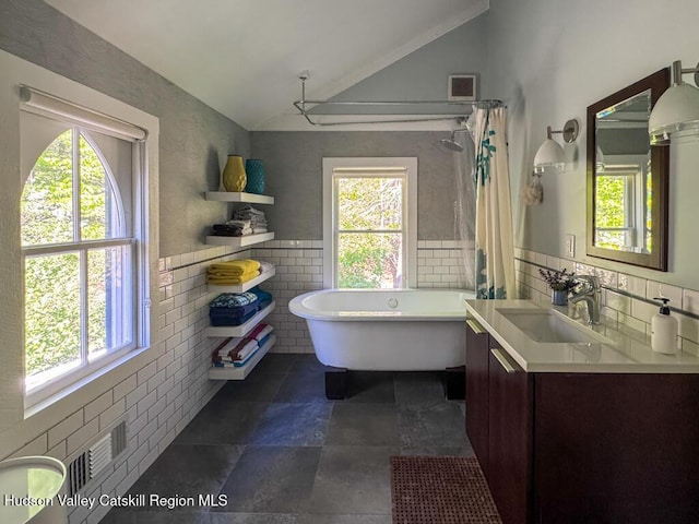 94 The Middle Way, Mount Tremper, NY 12457 - bathroom featuring vaulted ceiling, a freestanding bath, vanity, tile walls, and a shower with curtain