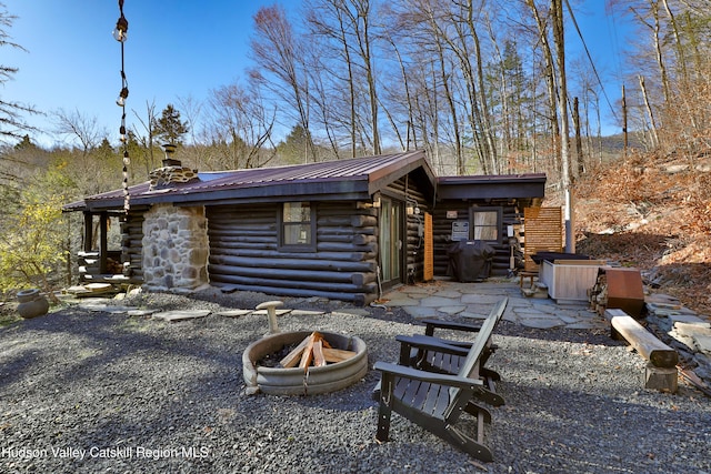 back of house featuring an outdoor fire pit and a patio