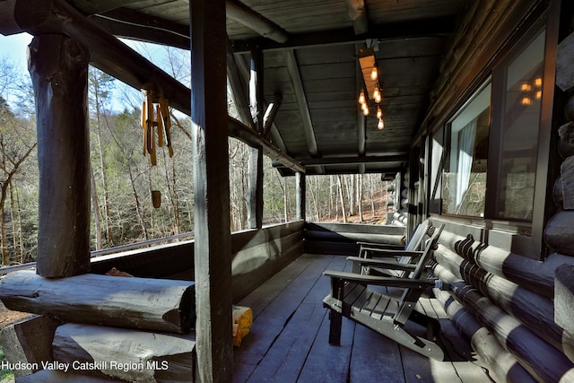 sunroom featuring plenty of natural light, wood ceiling, and vaulted ceiling with beams