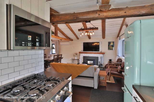 kitchen with a wood stove, white refrigerator, lofted ceiling with beams, and tasteful backsplash