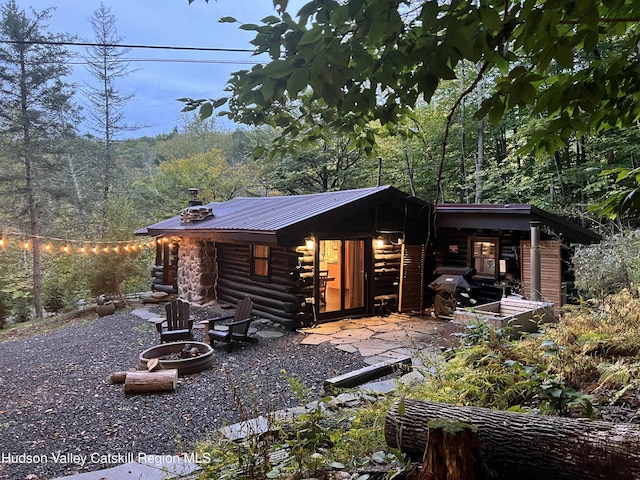 exterior space with an outdoor fire pit and a patio