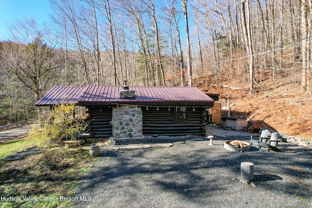 log-style house featuring an outdoor fire pit