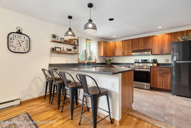 552 Bearkill Rd, Gilboa, NY 12076 - kitchen featuring freestanding refrigerator, under cabinet range hood, stainless steel electric range, dark countertops, and a breakfast bar area