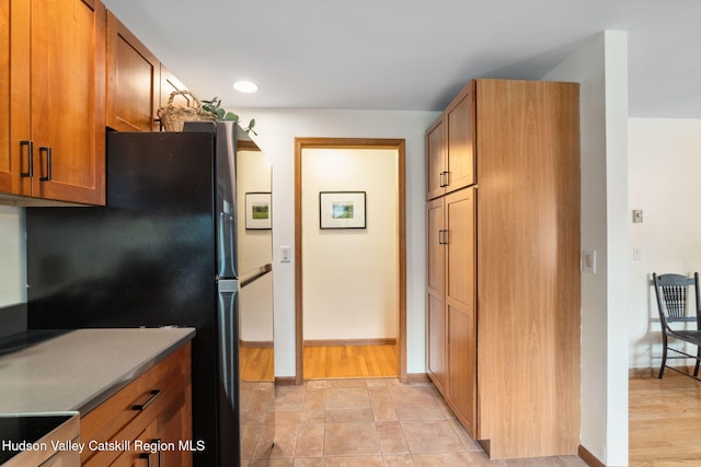 552 Bearkill Rd, Gilboa, NY 12076 - kitchen featuring brown cabinetry, freestanding refrigerator, stove, and recessed lighting