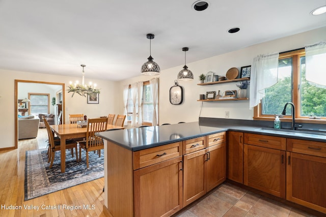 552 Bearkill Rd, Gilboa, NY 12076 - kitchen featuring dark countertops, pendant lighting, a peninsula, and a chandelier