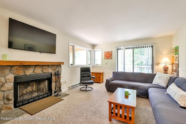 living room featuring a baseboard heating unit, healthy amount of natural light, a stone fireplace, and carpet flooring