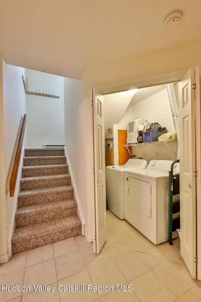 staircase with washer and dryer, tile patterned flooring, and baseboards