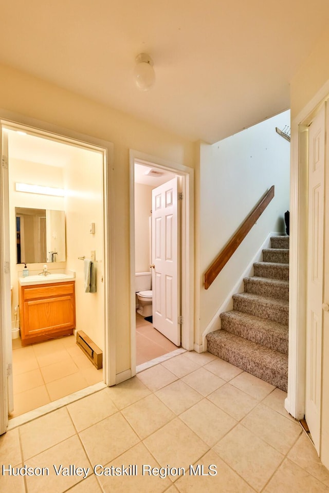 staircase featuring tile patterned flooring and a baseboard radiator