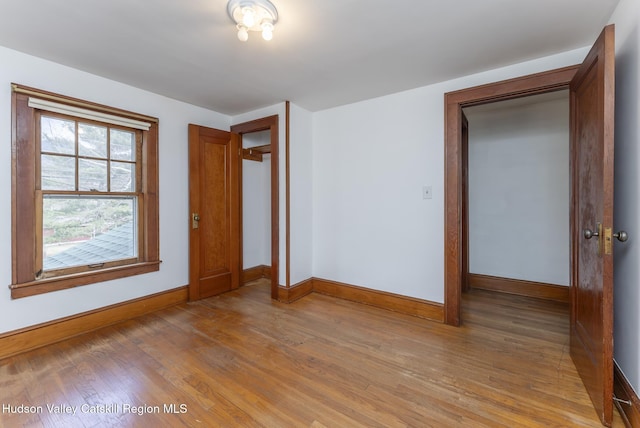 unfurnished bedroom with a closet, light wood-type flooring, and baseboards