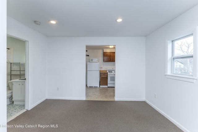 unfurnished living room with recessed lighting, baseboards, and carpet floors